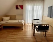 Monteurzimmer in Lippstadt mit Einzelbett, Fernseher, Tisch und Balkon