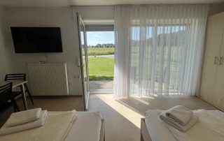 Ruhiges Doppelzimmer im Haus Stallmeister in Lippstadt mit zwei Betten, Fernseher und Blick ins Grüne